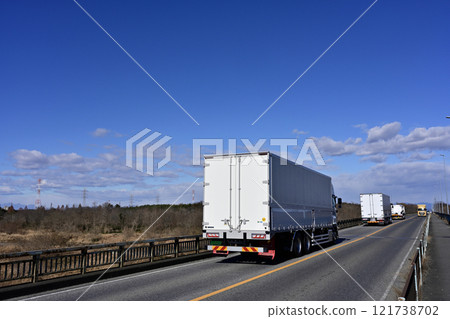 Large trucks supporting logistics running under blue skies 121738702