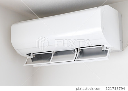A white air conditioner with the louvers facing downwards 121738794