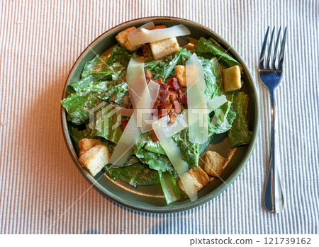 fresh green caesar salad with bacon and cheese on top 121739162