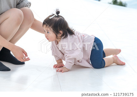 [Mother and infant crawling on giant playground equipment] 121739175