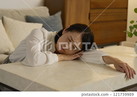 A tired woman in her 50s sleeping in the living room at night A tired woman in her 50s sleeping in the living room at night 121739989
