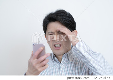 驚訝的中年男子看著他的智慧型手機螢幕 驚訝的中年男子看著他的智慧型手機螢幕 121740163