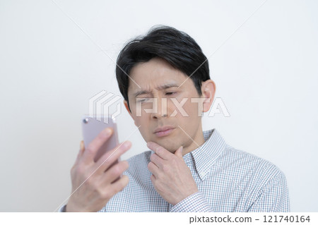 考慮智慧型手機螢幕的中年男子 考慮智慧型手機螢幕的中年男子 121740164
