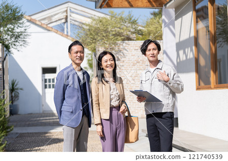 A businessman and a middle-aged couple having a meeting about renovation A businessman and a middle-aged couple having a meeting about renovation 121740539