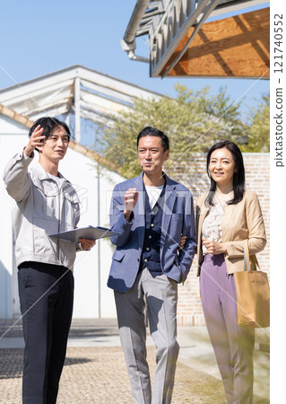 A businessman and a middle-aged couple working at a construction site A businessman and a middle-aged couple working at a construction site 121740552