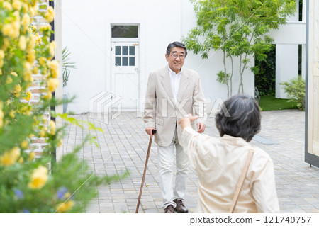 Senior couple walking with a cane 121740757