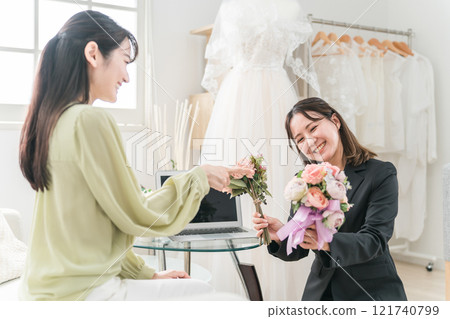 A woman having a meeting with a wedding planner to select a wedding bouquet A woman having a meeting with a wedding planner to select a wedding bouquet 121740799