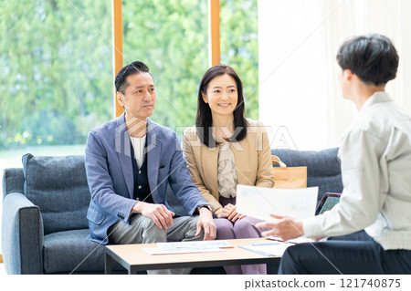 A businessman negotiating with a couple A businessman negotiating with a couple 121740875