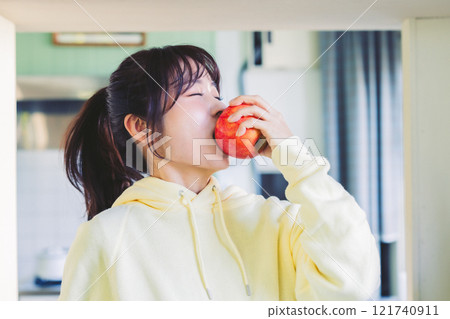 A woman biting an apple A woman biting an apple 121740911