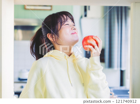 A woman biting an apple 121740912
