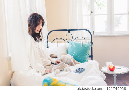 A woman relaxing on her bed on holiday A woman relaxing on her bed on holiday 121740938