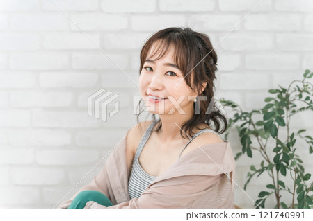 Fashionable Asian woman sitting on a chair and relaxing Fashionable Asian woman sitting on a chair and relaxing 121740991