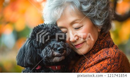 Heartwarming scene of elderly woman lovingly embracing small dog 121741854