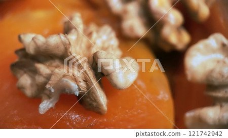 Traditional Turkish Pumpkin Dessert with Walnuts.A delectable close-up of a traditional Turkish pumpkin dessert topped with crunchy walnuts, showcasing its rich texture and vibrant colors.  121742942