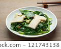close up view of stir fried chinese kale with hard tofu in a ceramic dish on wooden table. asian homemade style healthy food concept. 121743138