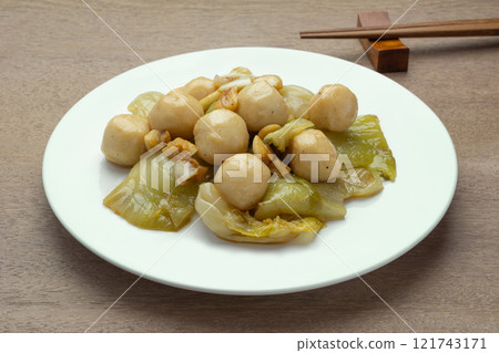 close up view of stir fried pickled mustard greens with fishball  in a ceramic dish on wooden table. asian homemade style food concept. 121743171