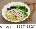 homemade style egg noodles and chicken with clear soup in a ceramic bowl on wooden table, close up. asian food concept. 121743325