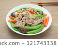homemade style of stir fried pork with sugar peas in a ceramic dish on wooden table, close up view. asian food concept. 121743338