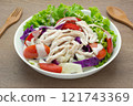 chicken meat salad and vegetables topped with mayonnaise sauce in a bowl on wooden table, close up view. homemade style healthy food concept. 121743369