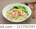 homemade style of egg noodles and shrimp with clear soup in a ceramic bowl on wooden table, close up. asian food concept. 121743393