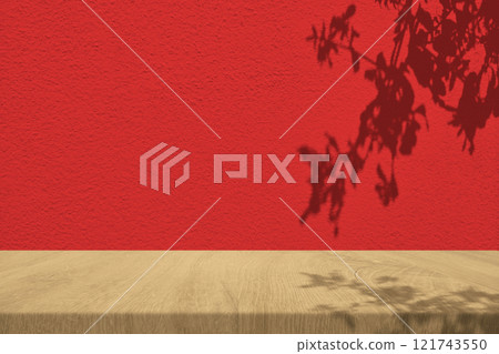 Light Brown Wooden Table with Pomegranate Leaves Shadow on Red Concrete Wall, Suitable for Product Presentation Backdrop, Display, and Mock up in Chinese New Year Concept. Light Brown Wooden Table with Pomegranate Leaves Shadow on Red Concrete Wall, Suitable for Product Presentation Backdrop, Display, and Mock up in Chinese New Year Concept. 121743550