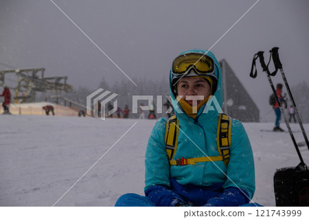 Skier Resting on Snowy Slope at Ski Resort 121743999