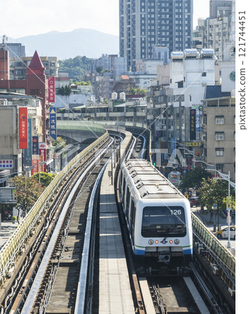 View of a Wenhu or Brown line train running on the elevated track of the Taipei Mass Rapid Transit System with the building background. View of a Wenhu or Brown line train running on the elevated track of the Taipei Mass Rapid Transit System with the building background. 121744451