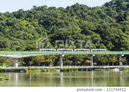 A train traveling on the Wenhu or Brown Line of the Taipei MRT, Taiwan, passes by Taipei Dahu Park. 121744452