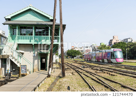 The circular light rail train drives past the former Kaohsiung Port Station North Signal Box, Taiwan. 121744470