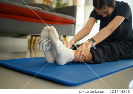 Sporty active woman doing stretching exercising on yoga mat in living room 121744868