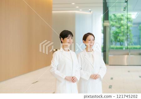 Portrait of two women in white coats 121745202