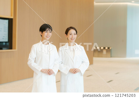 Portrait of two women in white coats 121745203