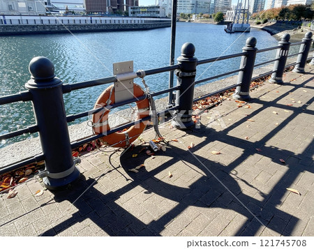 A lifebuoy hangs on a fence on an embankment in Japan 121745708