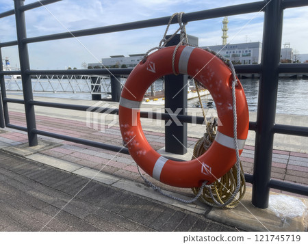 A lifebuoy hangs on a fence on an embankment in Yokohama, Japan 121745719
