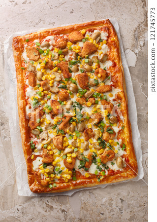 Puff open pie with chicken, mushrooms, corn, mozzarella cheese and tomato sauce close-up on parchment paper. Vertical top view 121745773
