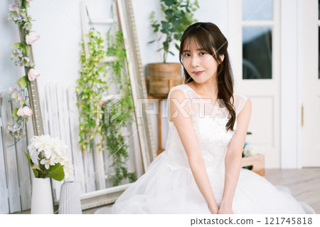 A young woman with long black hair wearing a wedding dress 121745818