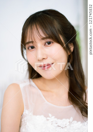 A young woman with long black hair wearing a wedding dress 121745832