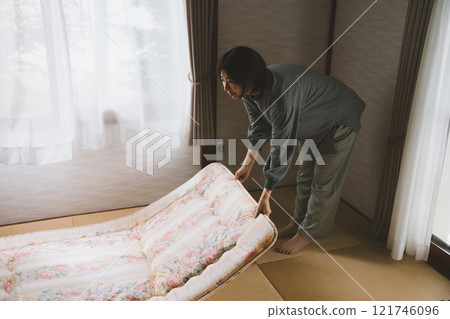 A woman laying a futon A woman laying a futon 121746096
