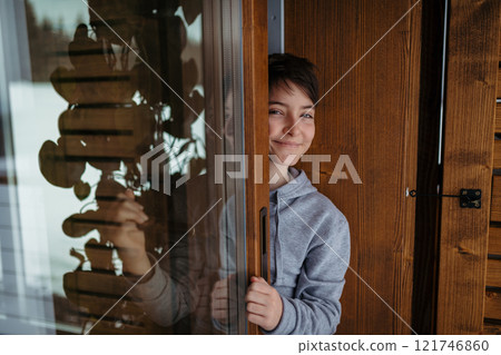 Cute girl standing on balcony and looking at snowfall. Cute girl standing on balcony and looking at snowfall. 121746860