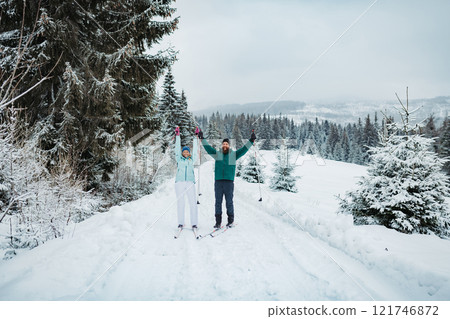 Couple cross country skiing in winter nature. Active winter holidays in a mountains. Couple cross country skiing in winter nature. Active winter holidays in a mountains. 121746872