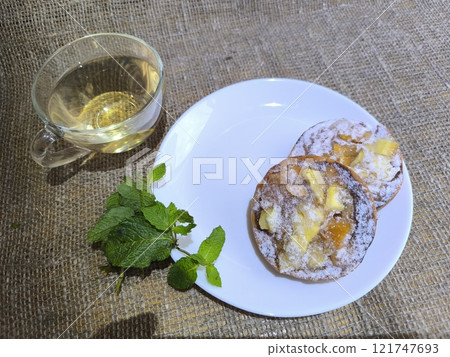 Fragrant pie on a white plate and hot tea. High-quality photo. 121747693