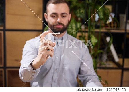 Young man dressed in formalwear and demonstrated spray for throat to remove pain in sore throat. Illness and treatment. 121748453