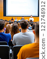A diverse group of college students in a lecture hall actively listening to presentations 121748912