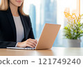 A Professional Woman is Actively Engaged in Working on Her Laptop in a Modern Office Environment 121749240