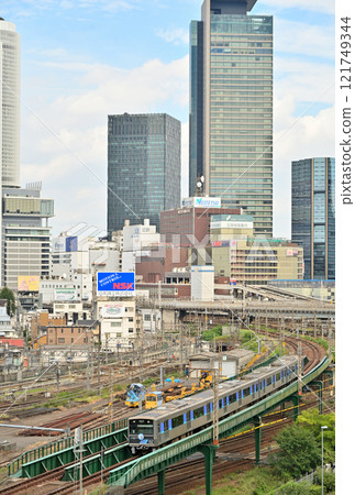 A train commemorating the 20th anniversary of the Aonami Line runs with the buildings of Nagoya Station in the background. 121749344