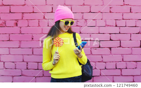 Modern caucasian young woman 20s with phone, teenage girl looking at smartphone in bright clothes Modern caucasian young woman 20s with phone, teenage girl looking at smartphone in bright clothes 121749460