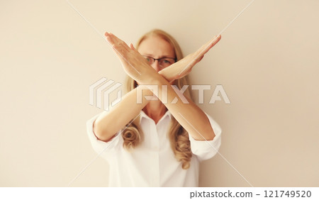 Upset woman shows stop, no or enough sign with palm of hand, refusal gesture, domestic violence Upset woman shows stop, no or enough sign with palm of hand, refusal gesture, domestic violence 121749520