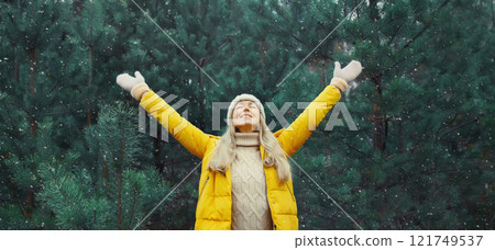 Winter day, happy smiling young woman enjoys snow, warm weather against Christmas tree 121749537