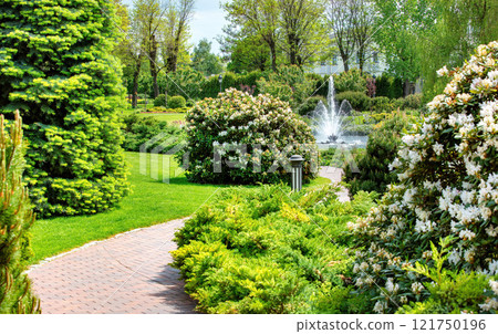Serenity unfolds in a lush garden adorned with vibrant flowers and a shimmering fountain Serenity unfolds in a lush garden adorned with vibrant flowers and a shimmering fountain 121750196