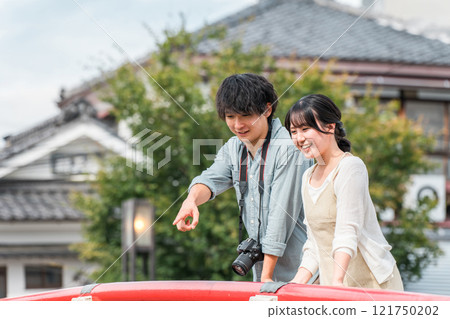 A young couple taking a walking tour of the castle town on a domestic trip 121750202